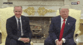two men in suits and ties are sitting next to each other in front of a fireplace in washington d.c.