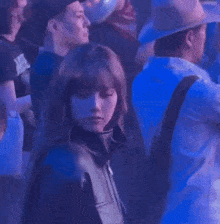 a woman is standing in the middle of a crowd of people at a concert .