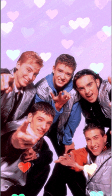 a group of young men are posing for a picture and pointing at the camera