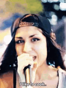 a woman singing into a microphone with the words " i like to cook " below her