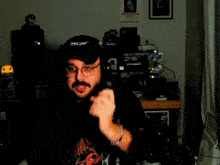 a man wearing headphones and a hat is dancing in a dark room with a wanted poster on the wall behind him