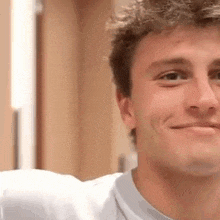 a close up of a man 's face smiling while looking at the camera .