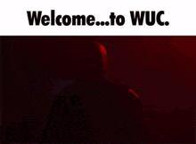 a man with a beard is standing in front of a red background with the words welcome to wuc written on it .
