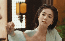a woman in a green dress looks at herself in the mirror