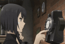 a girl is talking on a telephone with a clock behind her