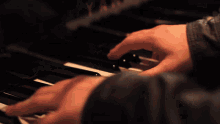 a person is playing a piano with their fingers on the keys