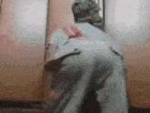 a person with a backpack standing in front of a door .