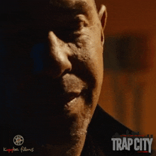 a close up of a man 's face with trap city written on the bottom