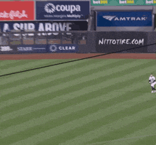 a baseball field with a sign that says coupa in the background