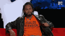 a man with dreadlocks is wearing an orange shirt that says legalize sension
