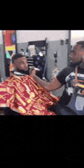 a man is getting his hair cut by a barber in a barbershop .
