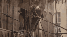 a group of men are standing on a scaffolding and the caption says " parke-mondion "
