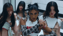 a woman in a plaid shirt is surrounded by a group of girls