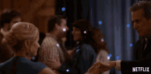 a group of people are dancing in front of a curtain that says netflix on it