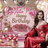 a woman in a red dress is sitting in front of a happy birthday banner
