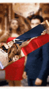 a woman in a red dress is laying on a man in a blue suit
