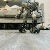 a toy robot is standing on a wooden floor