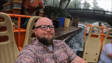 a man wearing glasses is taking a selfie in front of a statue