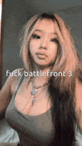 a woman with long hair is wearing a green tank top and a necklace with the words " fuck battlefront 3 " on the bottom