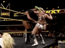 two women are wrestling in a ring with the word nxt in the background