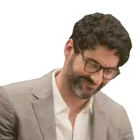 a man with glasses and a beard looks down at something