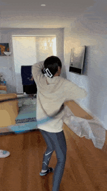 a woman is playing a video game in a living room with a hula hoop