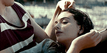 a woman is smoking a cigarette while laying next to a man