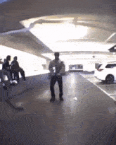a man is dancing in a parking garage