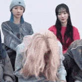 a group of girls are sitting in a row and one of them is kneeling down .