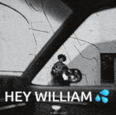 a black and white photo of a man standing in front of a wall with the words hey william