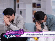 two men are praying in front of a fan live banner