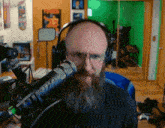 a man with a beard is wearing headphones and looking at the camera