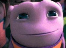 a close up of a purple cartoon character 's face with blue eyes .
