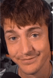 a close up of a man 's face with headphones on making a funny face .