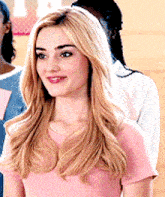 a woman in a pink shirt is standing in a line with other women .