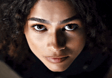 a close up of a woman 's face with a serious look on her face