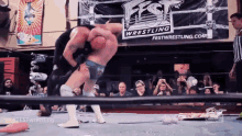 two men are wrestling in front of a sign that says fest wrestling