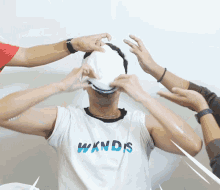 a man wearing a wknds t-shirt is being covered in a white substance