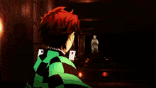 a man with red hair and a checkered shirt is standing in a dark room
