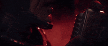 a close up of a person singing into a microphone with a red background