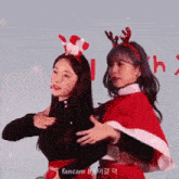 a couple of women are standing next to each other wearing christmas costumes .