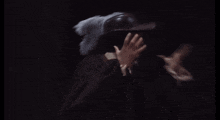 a man wearing a hat with feathers on it covering his face