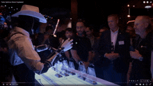 a group of people are standing around a table with a tesla live logo on it