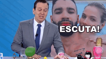 a man in a suit and tie stands in front of a picture of a man and a woman and says " escuta "