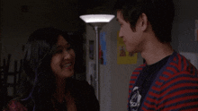 a man and a woman are smiling at each other in a dark room