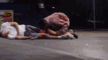 a man in a white shirt is laying on the ground next to a woman