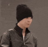 a close up of a person wearing a black beanie and a black jacket .