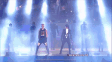a man in a tank top and a man in a suit are on stage