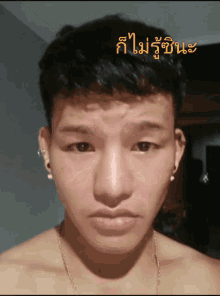 a young man without a shirt is looking at the camera with a foreign language written above him