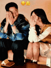 a man and a woman are sitting next to each other and covering their faces with their hands ..